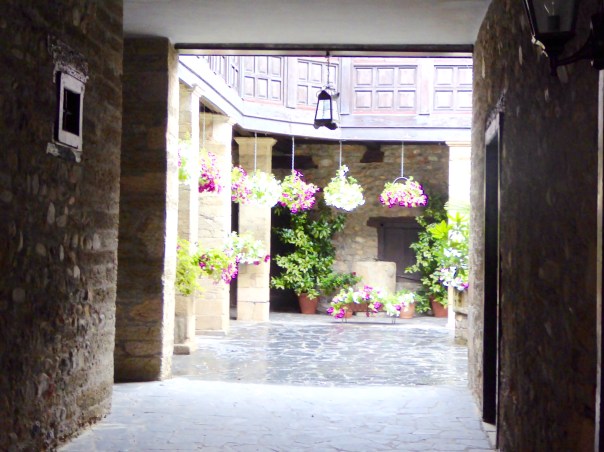 So many of the streets in Europe seem to be faced with buildings that come right to the sidewalk. In fact behind the car and front entrance doors are  entrance eays to beautiful courtyards. Here we are looking into a gardened area that is like a courtyard back garden.