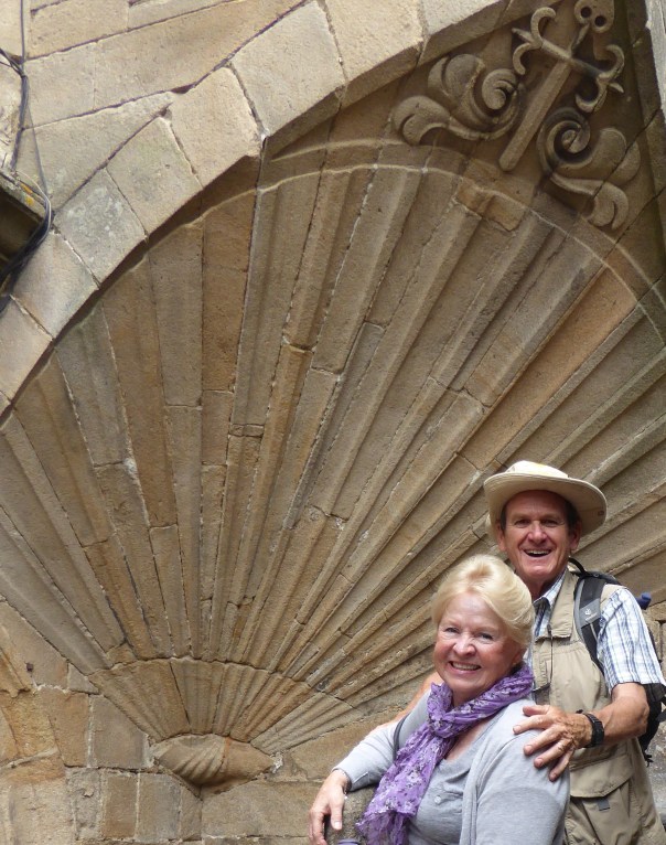 A more subdued couple standing before the giant she'll symbolizing the end of the Camino. 